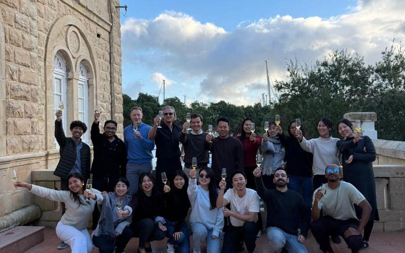 The SEO Butler team gathered on steps outside a stone building in Malta