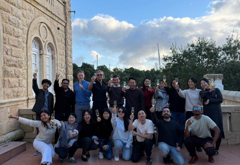 The SEO Butler team gathered on steps outside a stone building in Malta
