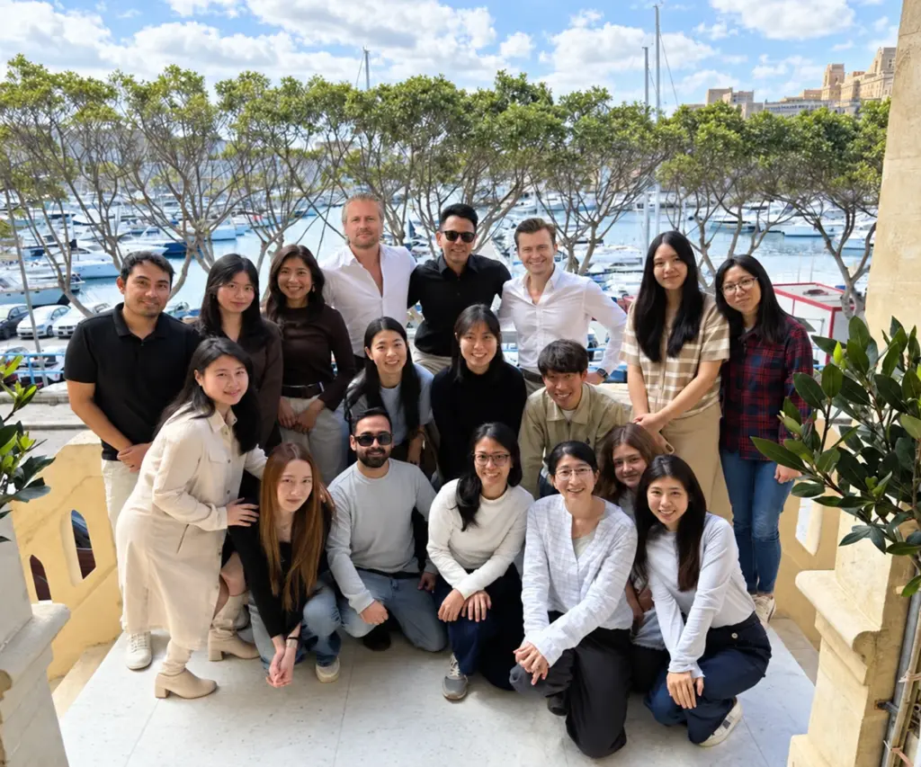 The SEO Butler team together on a balcony overlooking the marina in Ta' Xbiex, Malta